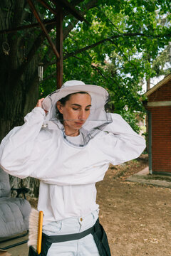 Bee farming. Female beekeeper prepares for the bee inspection