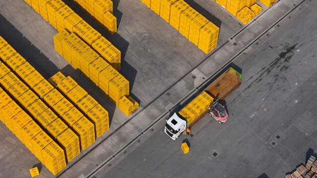 Pontenure, Italy - 30 March 2026: Aerial view of YTONG Xella Italia S.r.l. facility with stacks of yellow concrete blocks being loaded onto a truck by a forklift in an industrial yard.