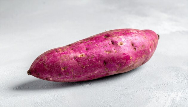 Single Fresh Purple Sweet Potato Whole Yam on Light Neutral Background