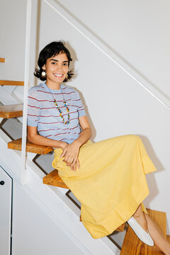 Woman smiling while sitting on modern staircase ugc