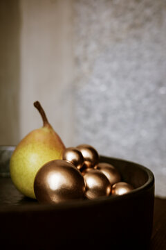 Fruit and Decorative Items Are Arranged in a Bowl on a Table