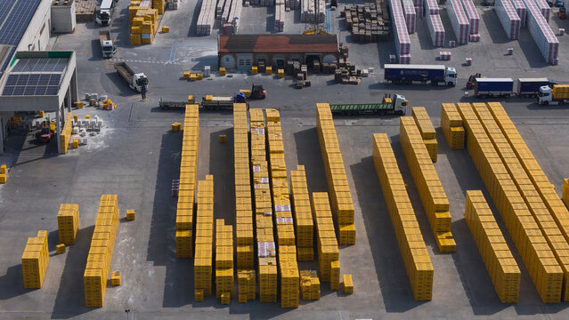 Pontenure, Emilia-Romagna, Italy - 30 March 2026: Aerial view of the YTONG Xella Italia facility, featuring stacks of yellow concrete blocks, parked trucks, and industrial infrastructure.