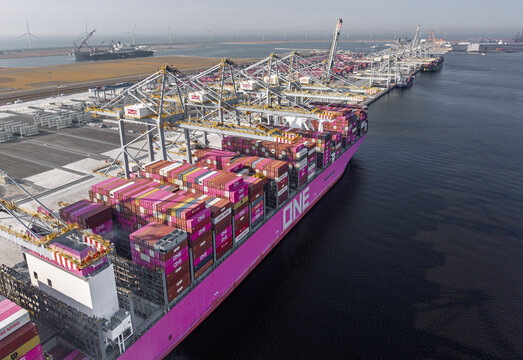 Maasvlakte Rotterdam, Netherlands - 03 August 2026: Aerial view of a large container ship docked at the Maasvlakte Rotterdam terminal with industrial cranes and colorful shipping containers.