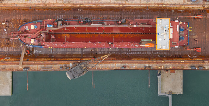 Thyboron, Denmark - 04 August 2026: Aerial view of Thyboron Shipyard, dry dock with Danish split trailing suction hopper dredger SIF R being cleaned.