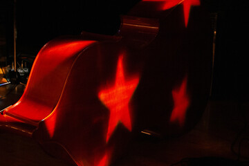 upright string bass resting on a stage with star stage lighting © Jerome