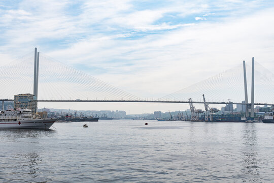  Vladivostok, Russia - July 17, 2026:    Golden Bridge Across Zolotoy Rog Bay with Ships and Seaport in Vladivostok.