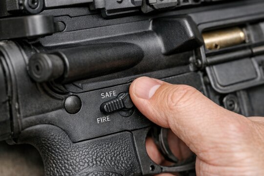 A person's hand presses the trigger of a gun
