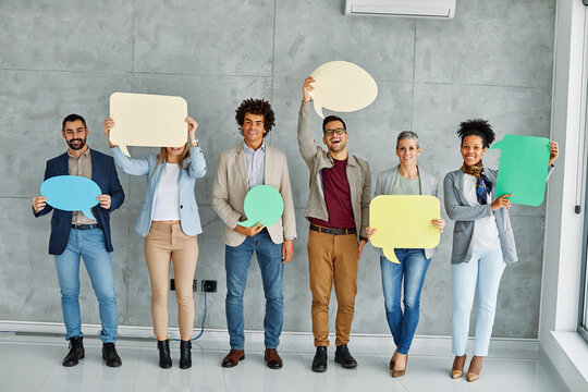 Portrait of a group of young business people in office. Speech bubble, team and comment by business people holding sign, news and voice icon feeling excited on social media. Group, opinion and poll by
