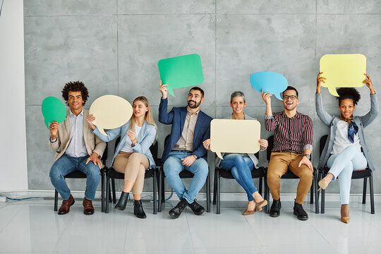 Portrait of a group of young business people in office. Speech bubble, team and comment by business people holding sign, news and voice icon feeling excited on social media. Group, opinion and poll by