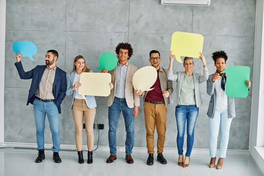 Portrait of a group of young business people in office. Speech bubble, team and comment by business people holding sign, news and voice icon feeling excited on social media. Group, opinion and poll by