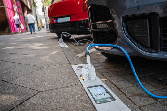 Ein E-Auto wird an einem Ladebordstein auf der K&Ouml; mit einem Kabel aufgeladen, D&uuml;sseldorf, Deutschland
