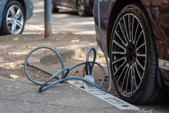 Ein E-Auto wird an einem Ladebordstein auf der K&Ouml; mit einem Kabel aufgeladen, D&uuml;sseldorf, Deutschland