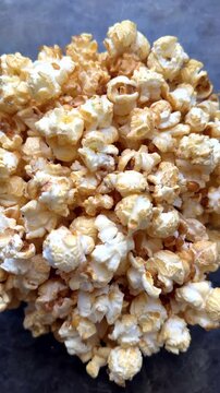 Close-up view of freshly popped popcorn with golden crispy kernels, detailed texture and appetizing snack background, movie theater food and entertainment concept