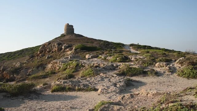 Landscape view of San Giovanni in Sinis at sunset, promontory with the Spanish tower and the coast, Sardinia, Italy.