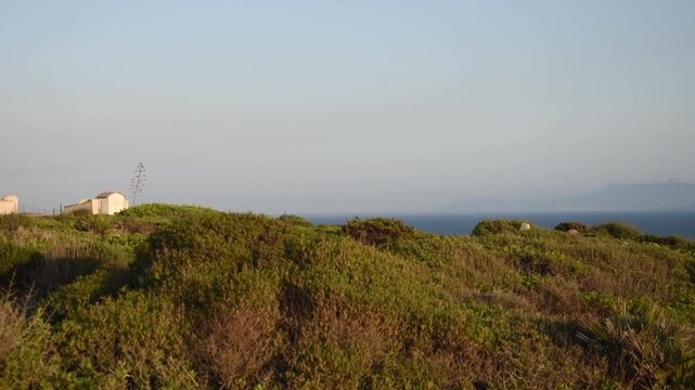 Landscape view of San Giovanni in Sinis at sunset, promontory of Capo San Marco with the lighthouse and the coast, Sardinia, Italy.