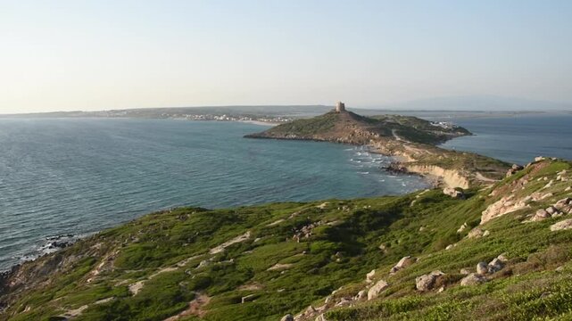 Landscape view of San Giovanni in Sinis at sunset, promontory with the Spanish tower and the coast, Sardinia, Italy.