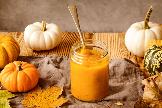 Rustic autumn pumpkin puree in jar with seasonal decor