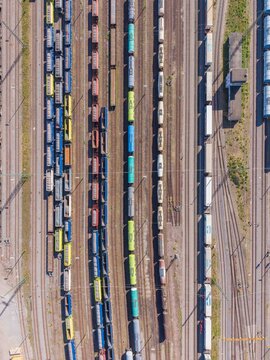Karlsruhe, Germany - 29 July 2026: Aerial view of a busy rail yard in Karlsruhe featuring multiple parallel tracks filled with colorful freight train cars and containers.