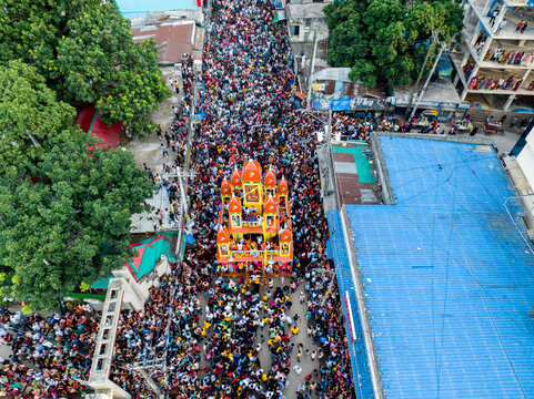 Savar, Bangladesh - 15 July 2024: Aerial view of a large crowd participating in the Rath Yatra chariot festival, with the ornate chariot pulled through the street.