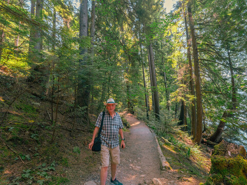 Octogenarian male enjoying a walk in the woods on an easy-walking BC urban forest trail.