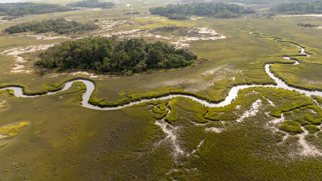 Drone view of lowcountry marshland showing winding creek and island during daylight