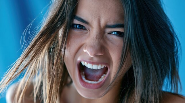 Angry woman screams with clenched teeth and furrowed brows
