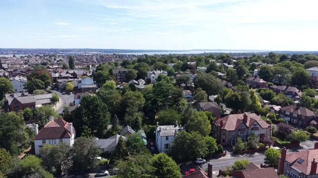 Aerial drone 4K footage showing Wirral housing blocks illuminated by warm afternoon daylight with bright natural highlights Wirral