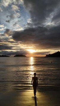 Woman Walking into the Ocean at Sunset, Playa Penca Guanacaste, Costa Rica &ndash; Aerial Drone 4K