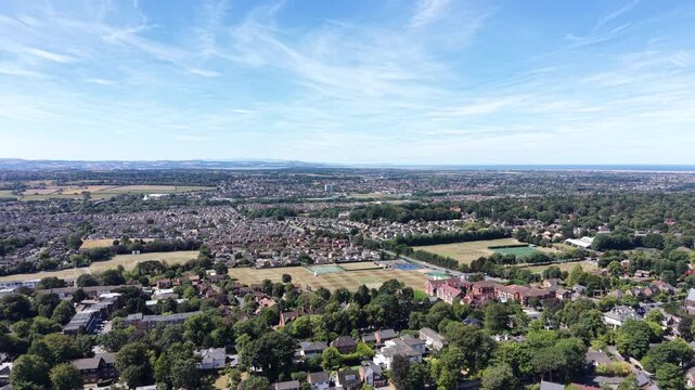 Aerial drone 4K clip showing long rows of Wirral homes illuminated by warm afternoon tones with crisp natural brightness Wirral