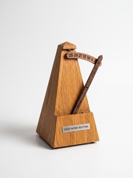 Wooden metronome with deep work rhythm label on a white background, representing the Pomodoro Technique and productivity management concept