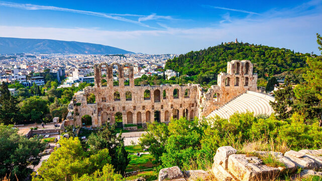 Ancient Odeon Ruins in Athens Greece with Cityscape and Green Hill