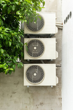 air conditioning units installed in a row on the exterior wall of a building. A simple urban detail illustrating cooling systems, residential infrastructure, energy use, and modern climate control