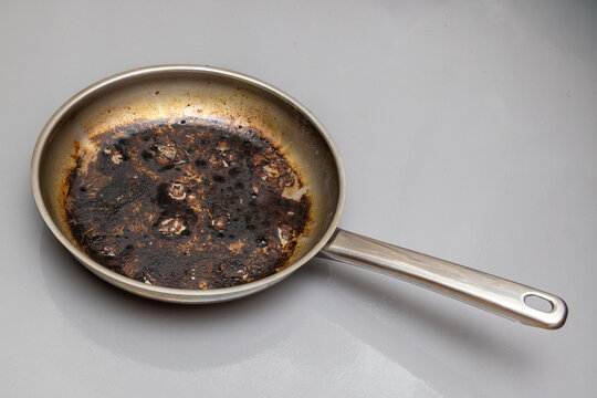 Burnt Frying Pan on Reflective Gray Surface