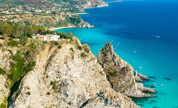 Capo Vaticano lighthouse Calabria Italy 70mm telephoto view vertical cliffs turquoise sea boats anchored below dramatic coastline landscape travel destination