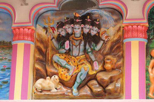 Colorful statue of five-headed Panchamukha Shiva inside a traditional Hindu temple wall niche.