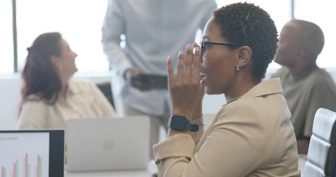 Diverse team watching African woman blazer adjusting glasses, replying to tablet speaker in meeting