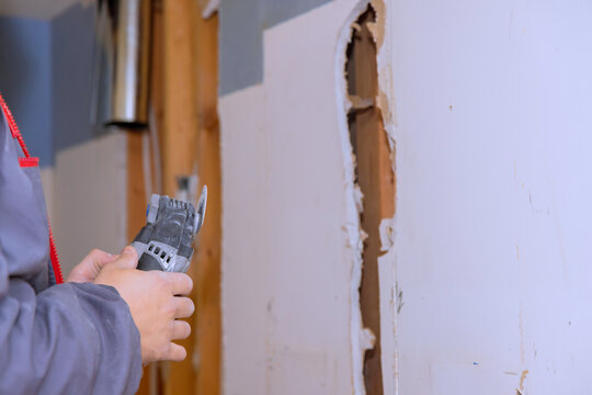 Work on wall repair in home with tool being used for cutting drywall