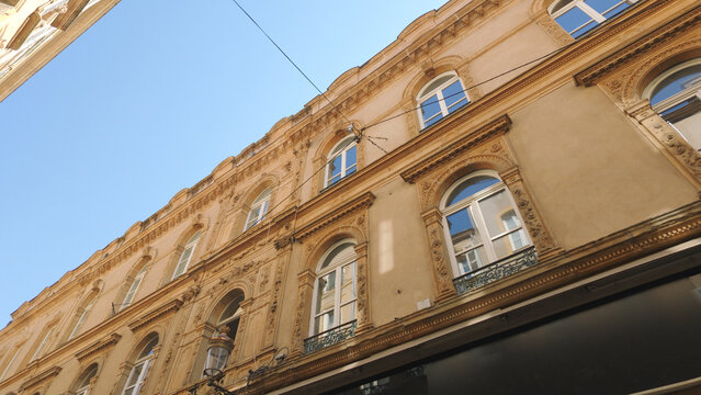Looking up at an old European building facade with decorative architectural details
