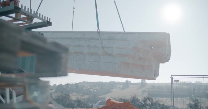 Crane lifting a heavy precast concrete element at a construction site