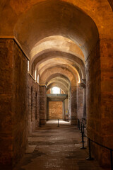 Fototapeta premium Stone arches line a dim, ancient hallway
