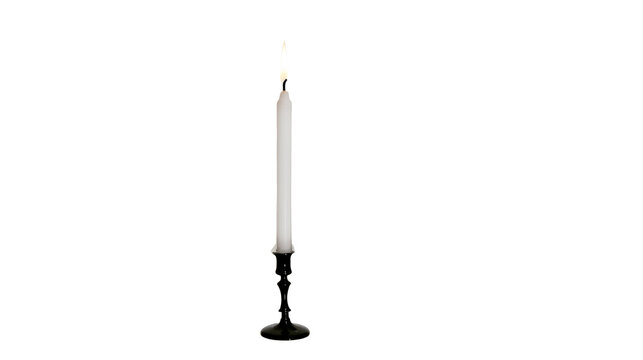 Lit white taper candle in black candlestick holder isolated on transparent background for png digital design projects