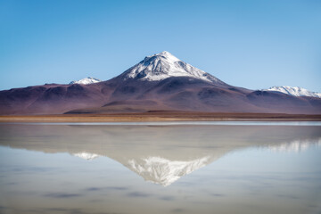 Fototapeta premium Stunning snowcapped volcano reflecting in salt lake in Bolivia 2024