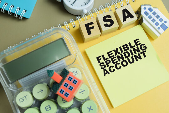Concept of FSA - Flexible Spending Account write on sticky notes isolated on Wooden Table.