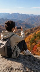 Fototapeta premium Woman Photographing Autumn Mountains from Rocky Viewpoint
