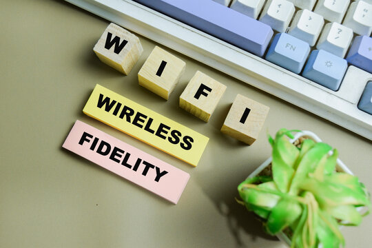 Concept of WIFI - Wireless Fidelity write on sticky notes isolated on Wooden Table.