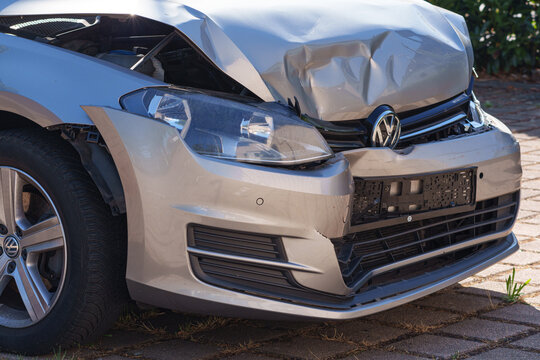 Dusseldorf, Germany - August 8 2026: Damaged Volkswagen car showing a crushed hood, front bumper and exposed headlight