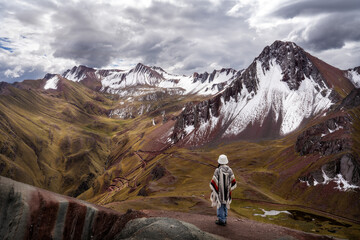 Fototapeta premium Solo traveler overlooking Palccoyo Rainbow Mountain landscape in Peru 2025