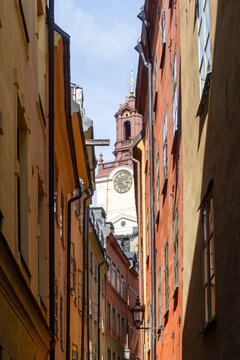 Gamla Stan narrow alley with Storkyrkan clock tower in Stockholm
