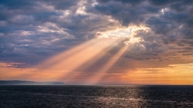 Crepuscular rays god rays through clouds over English Channel at evening, High-Resolution Travel and Nature Stock Photo.
