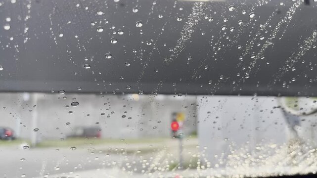 ドライブスルー洗車で車の窓を洗浄する場面